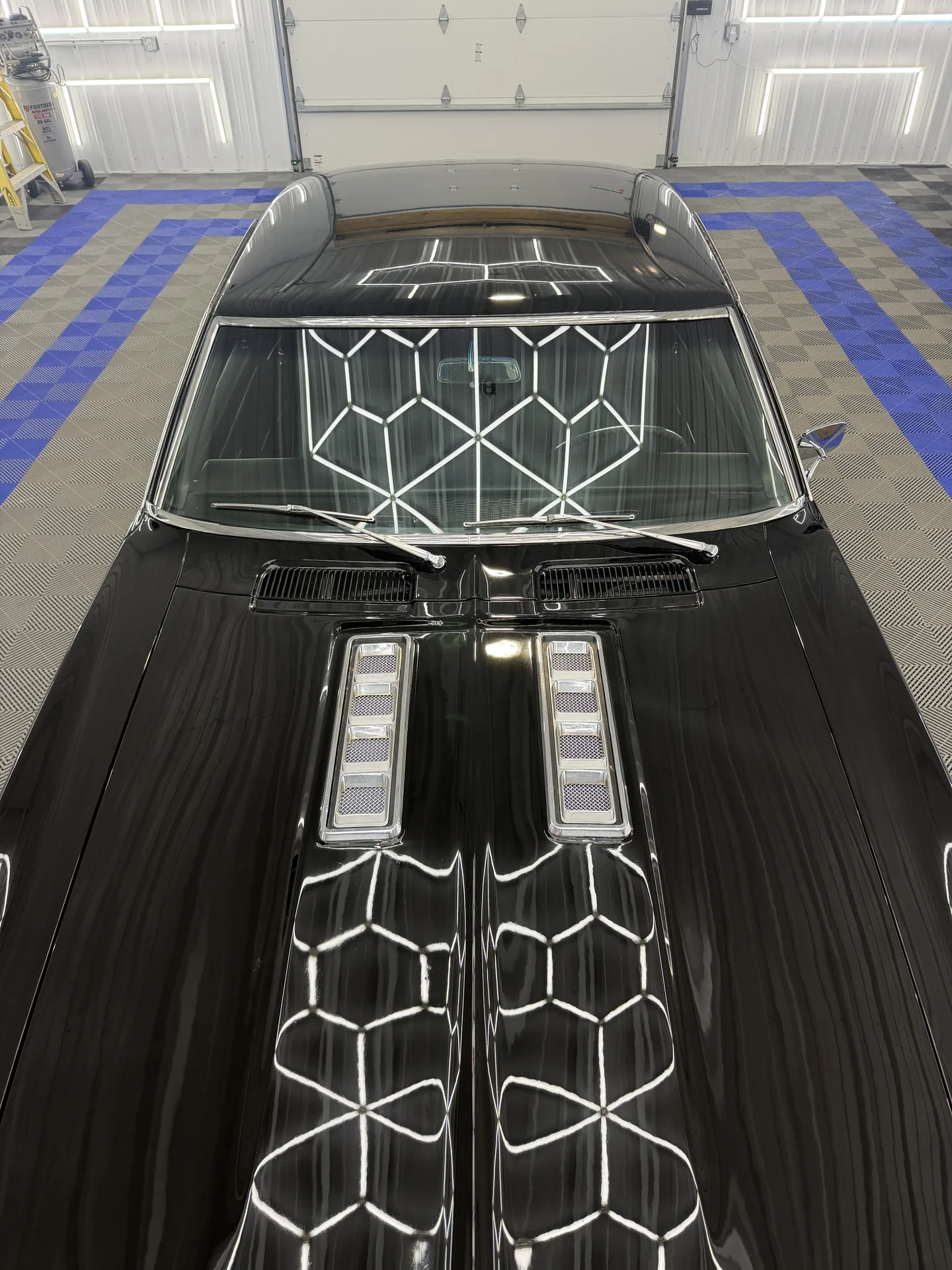 Black muscle car under the shop lights in the Porter's Detailing bay in Grant Park, Illinois